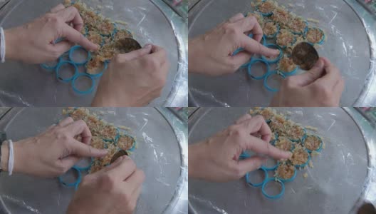女用手把拌有西瓜汁的米放在模具里做成炒年糕。米饼是泰国的传统小吃。高清在线视频素材下载
