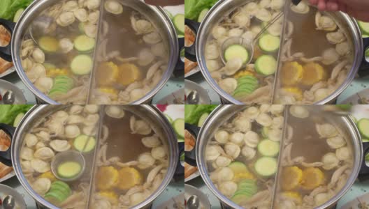 概念火锅亚洲料理。把蘑菇和西葫芦从沸腾的汤中撇出来高清在线视频素材下载