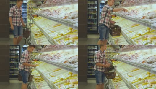 一个年轻人推着购物车在超市的冷藏区购买冷藏食品。一个人走到商店的冰箱前，拿起商品放进篮子里高清在线视频素材下载