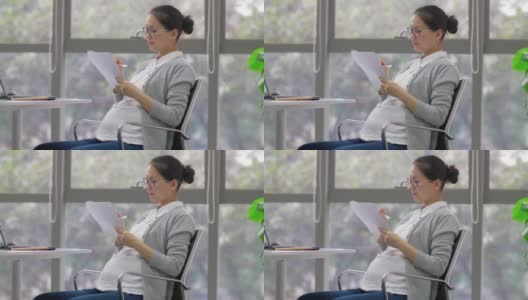 一名中国孕妇在办公室做记录高清在线视频素材下载