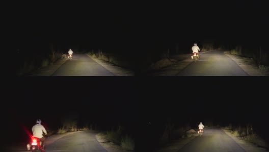 在柏油路上开车的4k视频。在柏油路上，司机超过一个骑自行车的人和一辆车的前灯。道路上的大灯光束具有极强的聚焦光。高清在线视频素材下载