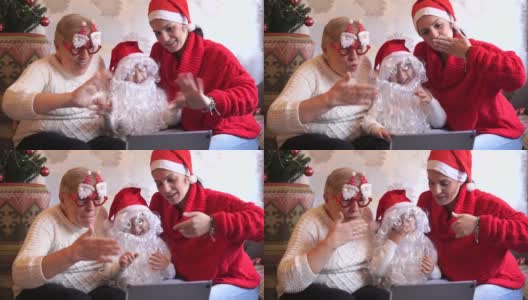 一家人戴着红色的圣诞帽和滑稽的眼镜，开着视频会议高清在线视频素材下载
