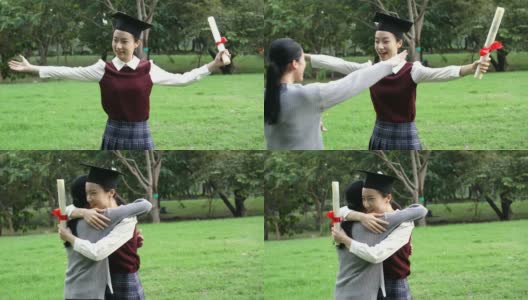 年轻的亚洲女毕业生在毕业典礼上拥抱她的朋友。国际多元化背景高清在线视频素材下载