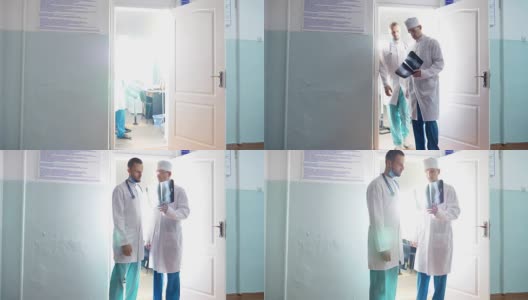 两个白人医生从柜子里出来，看核磁共振成像。男医生通过x光互相展示一些东西。同事们在医院散步。背景。前视图高清在线视频素材下载