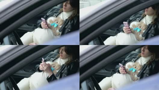 孕妇在车里玩智能手机高清在线视频素材下载