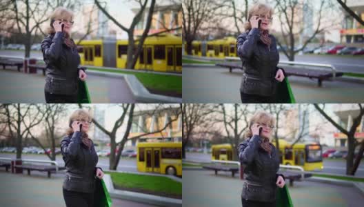 一位迷人的中年妇女走在街上，讲着电话。慢动作高清在线视频素材下载