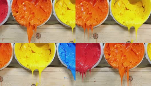 蓝色、黄色、橙色和红色的印刷t恤油墨从桶中流出高清在线视频素材下载