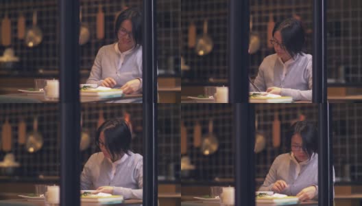 美丽的中国女人正在用手机吃饭高清在线视频素材下载