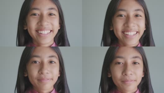 肖像亚洲女孩幸福的微笑，而站在孤立的蓝色背景高清在线视频素材下载
