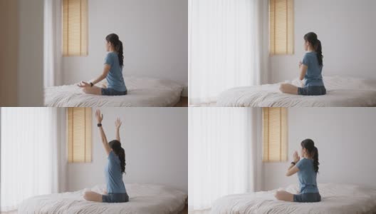 亚洲人早起健康生活平衡的好处瑜伽姿势在床上。高清在线视频素材下载