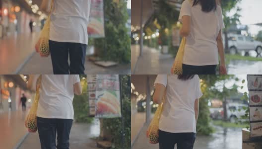 亚洲妇女行走在城市与可重复使用的袋子购物高清在线视频素材下载