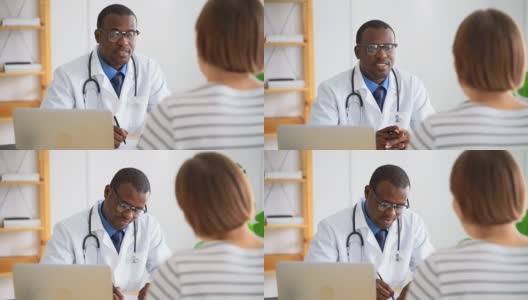 医生在医院为病人咨询健康状况。非洲黑人男性医生与女性交谈高清在线视频素材下载