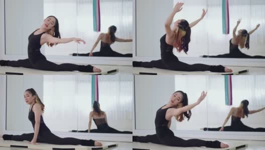 漂亮年轻的亚洲妇女在瑜伽坐侧风角度pose在健身室的白色垫子上。苗条的女孩穿着黑色运动服做有氧运动，坐着侧伸展姿势，手臂伸展，抬起脸。高清在线视频素材下载