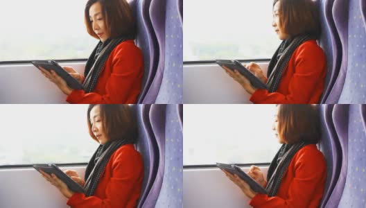 亚洲女性在火车上玩平板电脑。高清在线视频素材下载