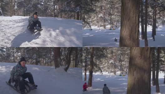 男孩坐在雪橇上往山下走高清在线视频素材下载