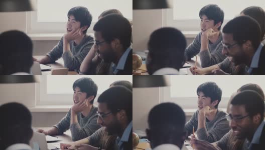 特写快乐的日本年轻员工听和笑在一起的同事在多民族办公室会议高清在线视频素材下载