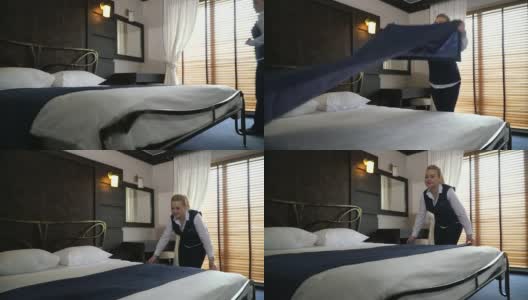 微笑的管理人员在酒店的现代房间纠正床上用品。缓慢的运动。高清在线视频素材下载