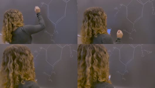 年轻的学生用智能手机在黑板上解决化学问题高清在线视频素材下载