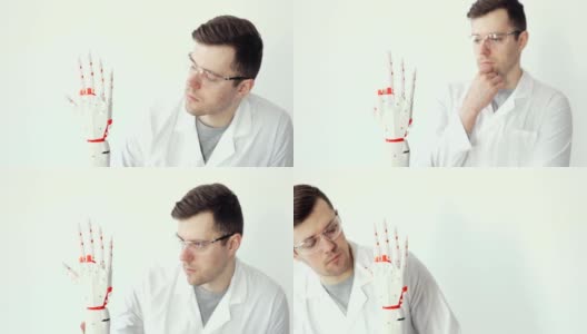 工程师科学家正在测试用手指做动作的机器人假肢手。仔细研究它是如何工作的高清在线视频素材下载