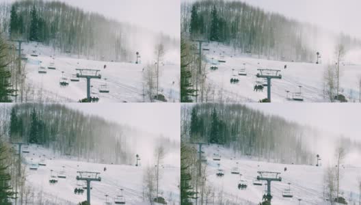 滑雪者和单板滑雪者乘坐滑雪缆车，人们在冬季科罗拉多山滑雪胜地的斜坡上滑雪(比弗溪)高清在线视频素材下载