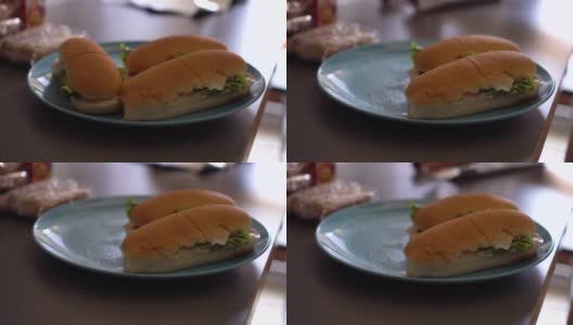 灰色桌子上的一个海蓝宝石盘子里放着新鲜的三明治。高清在线视频素材下载