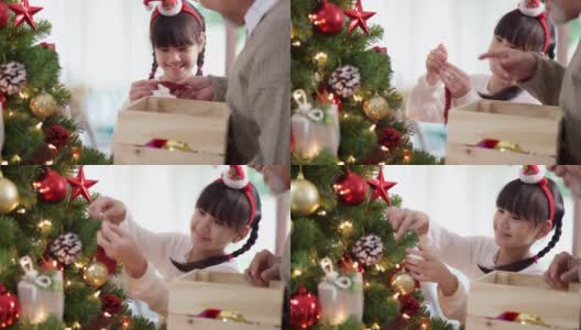 快乐的亚洲女孩和她的祖父几世同堂装饰圣诞树一起准备快乐的节日冬天。高清在线视频素材下载