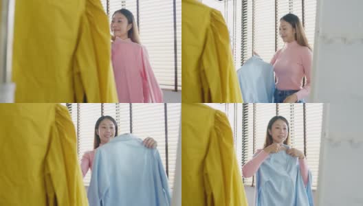 美丽迷人的亚洲女士在衣柜上挑选衣服，在家卧室里照镜子梳妆。高清在线视频素材下载
