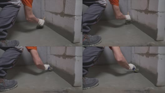 用混合物给地板防水。用手在桶里搅拌防水砂浆。男手拿刷子在地板上涂抹防水材料。桶内的防水溶液高清在线视频素材下载