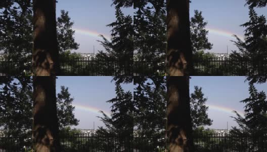 彩虹穿过树林在城市上空划过高清在线视频素材下载