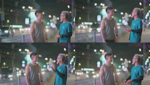 亚洲华人活跃的老人和他的儿子在晚上一起跑步锻炼后散步聊天城市高清在线视频素材下载