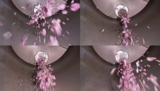 在蒸馏瓶中倒入粉红玫瑰花，香精油生产高清在线视频素材下载