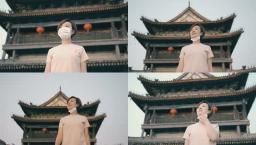 日落时分西安古城墙上的亚洲女人面具高清在线视频素材下载