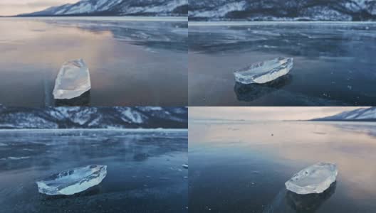 浮冰在冰面上旋转，映衬着令人惊叹的山景。缓慢的运动。镜头移到了冰的后面。冰在冰上旋转，有神奇的裂缝，非常漂亮。高清在线视频素材下载