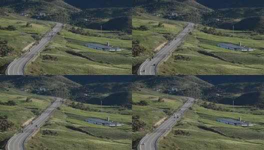 在阳光明媚的日子里，绿油油的山路和车流景观高清在线视频素材下载