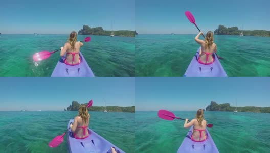 特写:年轻的女游客驾驶着她的皮划艇绕着美丽的翡翠海航行。高清在线视频素材下载