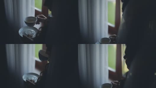 近景黑发女人看向远处和饮茶。早上一个人在家的女性高清在线视频素材下载