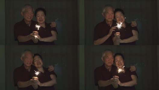 亚洲老夫妇玩烟花，烟花，爆竹在晚上。庆祝生活的概念高清在线视频素材下载