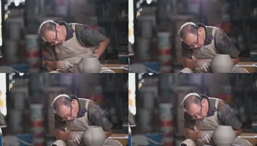 亚洲华人高级泥塑艺术家在他的工作室与纺织陶轮工作高清在线视频素材下载