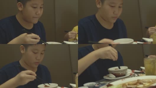 亚洲男孩与家人在餐厅吃素喜烧，涮涮锅或火锅，生活方式概念。高清在线视频素材下载