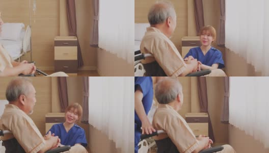 在医院照顾坐在轮椅上的成熟男性病人的亚洲护士。年轻女子推着轮椅，然后坐下来微笑着和老人交谈。待客医疗服务理念。高清在线视频素材下载