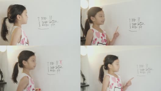 快乐的亚洲女孩在家庭教育期间在白板上写下数学科目的问题和答案，呆在家里的概念。高清在线视频素材下载