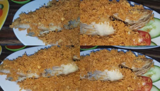 美味的印尼海鲜炒黑鲷鱼与油炸调味面糊，香料，浅盘与其他背景菜在印尼餐厅高清在线视频素材下载