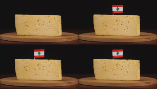 男人的手把小的有黎巴嫩国旗的牙签放在奶酪上。高清在线视频素材下载
