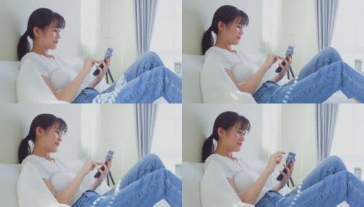 亚洲美女用手机打电话在床上在家里早上。快乐随意的漂亮女性躺在卧室享受假日周末，在家里用智能手机和科技交流。高清在线视频素材下载