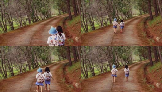 阳光明媚的日子里，两个小妹妹手牵着手沿着松林路向前奔跑。高清在线视频素材下载