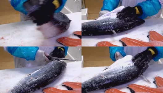 在鱼厂的桌子上，工人正在切一片鲑鱼片。多莉拍摄高清在线视频素材下载