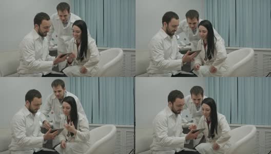 一组医生在医务室用平板电脑看一些有趣的东西高清在线视频素材下载