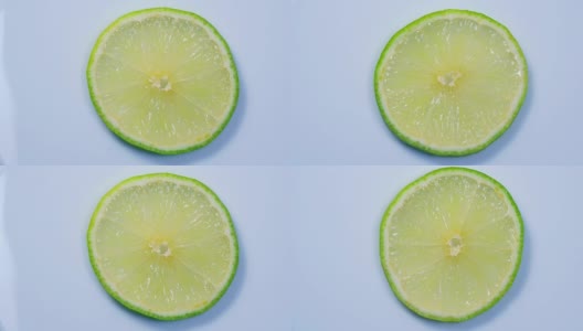 新鲜的绿色柠檬片随着细节在工作室中慢慢旋转。高清在线视频素材下载