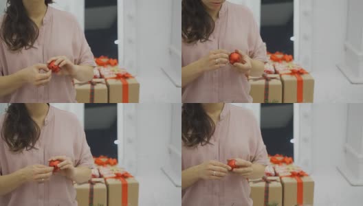 一个女人正抱着一个红色的圣诞树彩球装饰旋转高清在线视频素材下载
