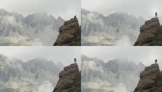 当恶劣天气逼近时，一名登山者正在攀登高山脊上的岩石堆。高清在线视频素材下载